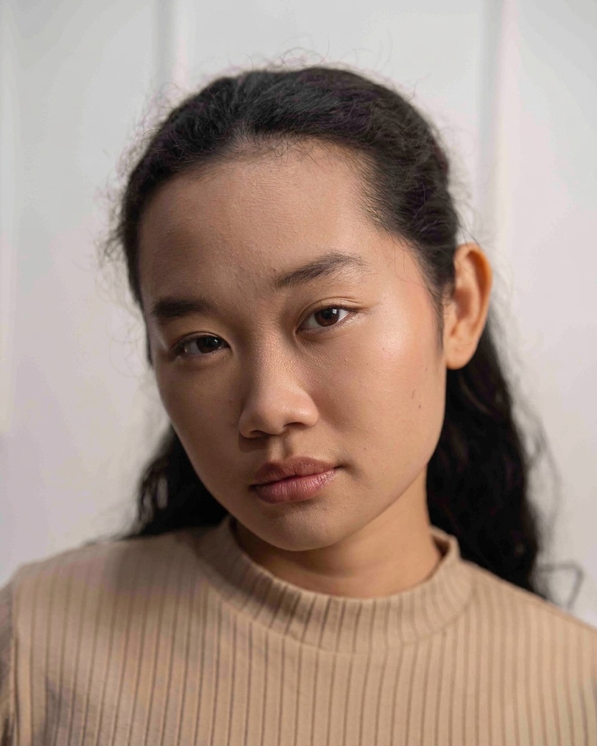 Amelia Ali studio headshot in a beige mock-neck top